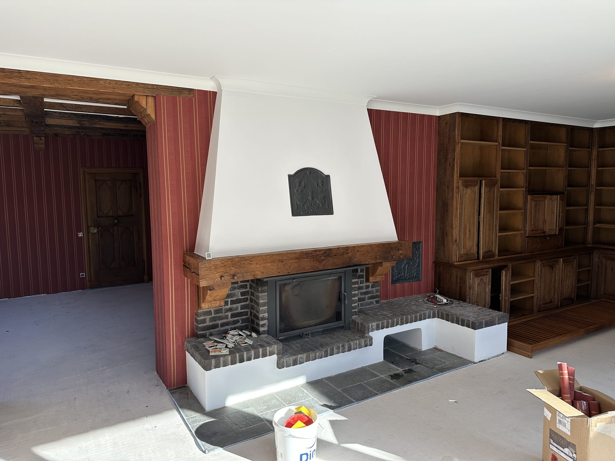 Wohnraum mit Streifentapete und frisch gestrichenen weißen Wand- und Deckenflächen